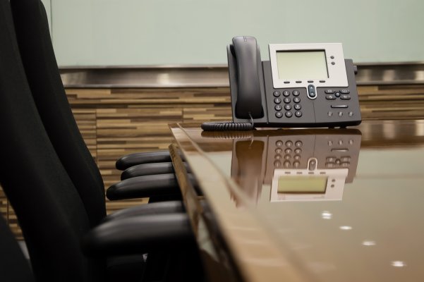 nextiva enterprise voip service office phone on table office black chairs